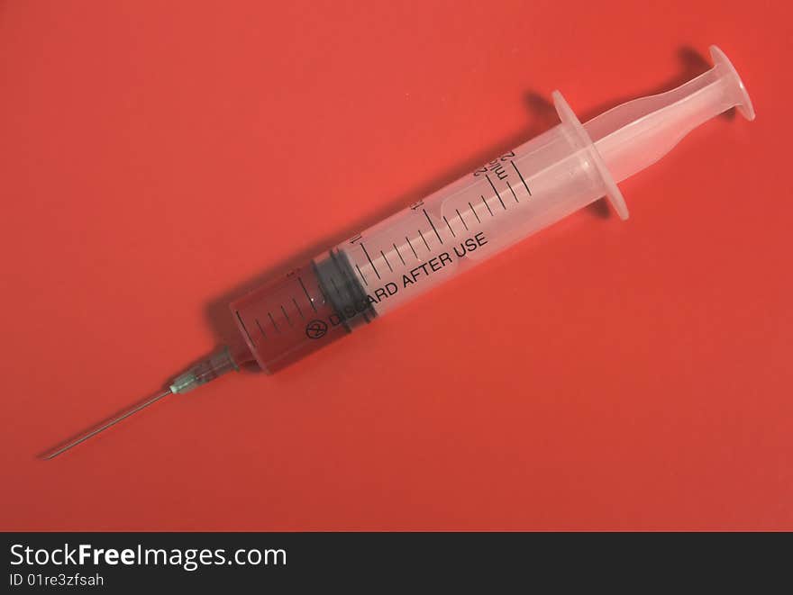 Syringe on red