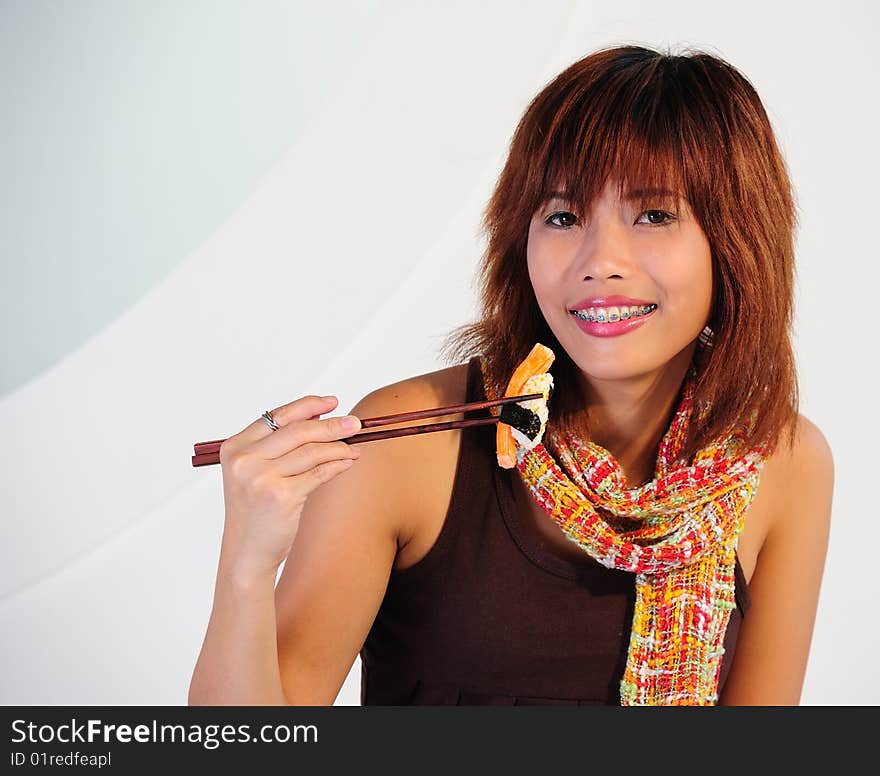 Young Asian Woman Eating Sushi