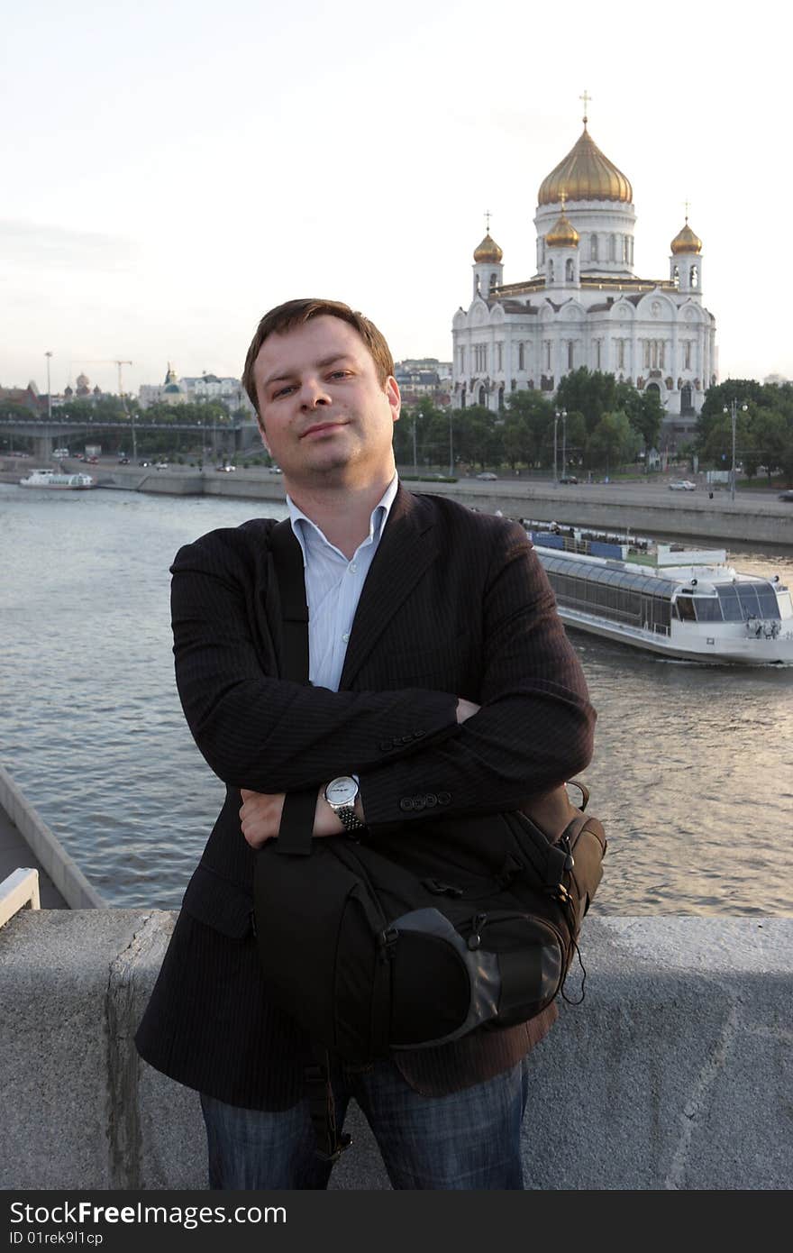 The tourist poses on a church background. The tourist poses on a church background