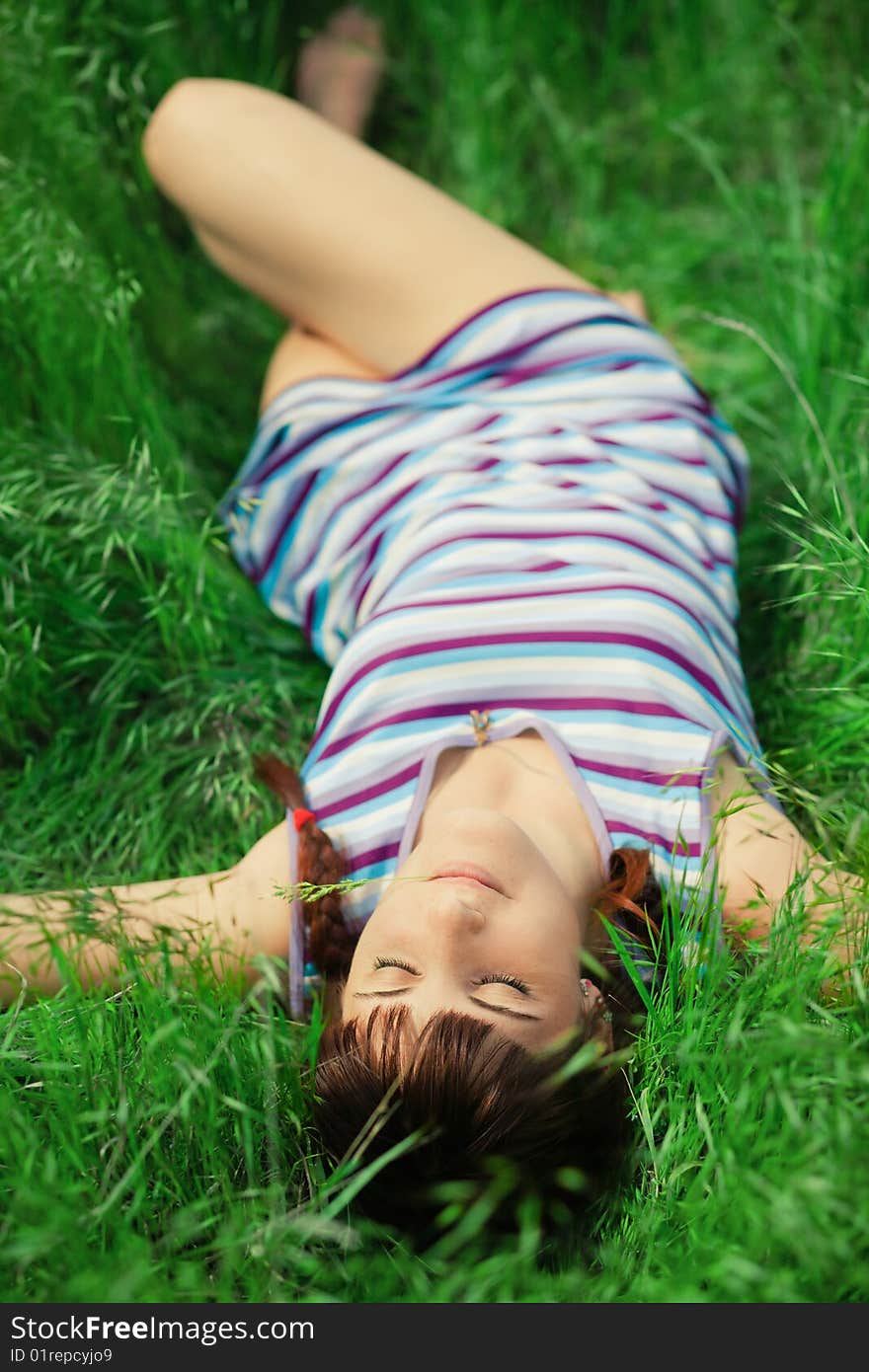 Young pretty girl lying in green grass. Young pretty girl lying in green grass