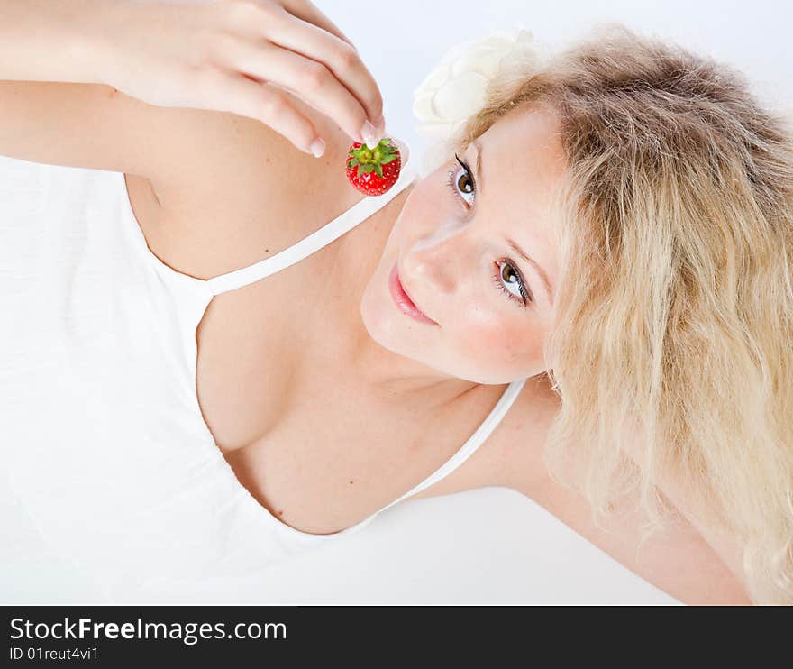 Young woman in white dress eating strawberries. Isolated on white background