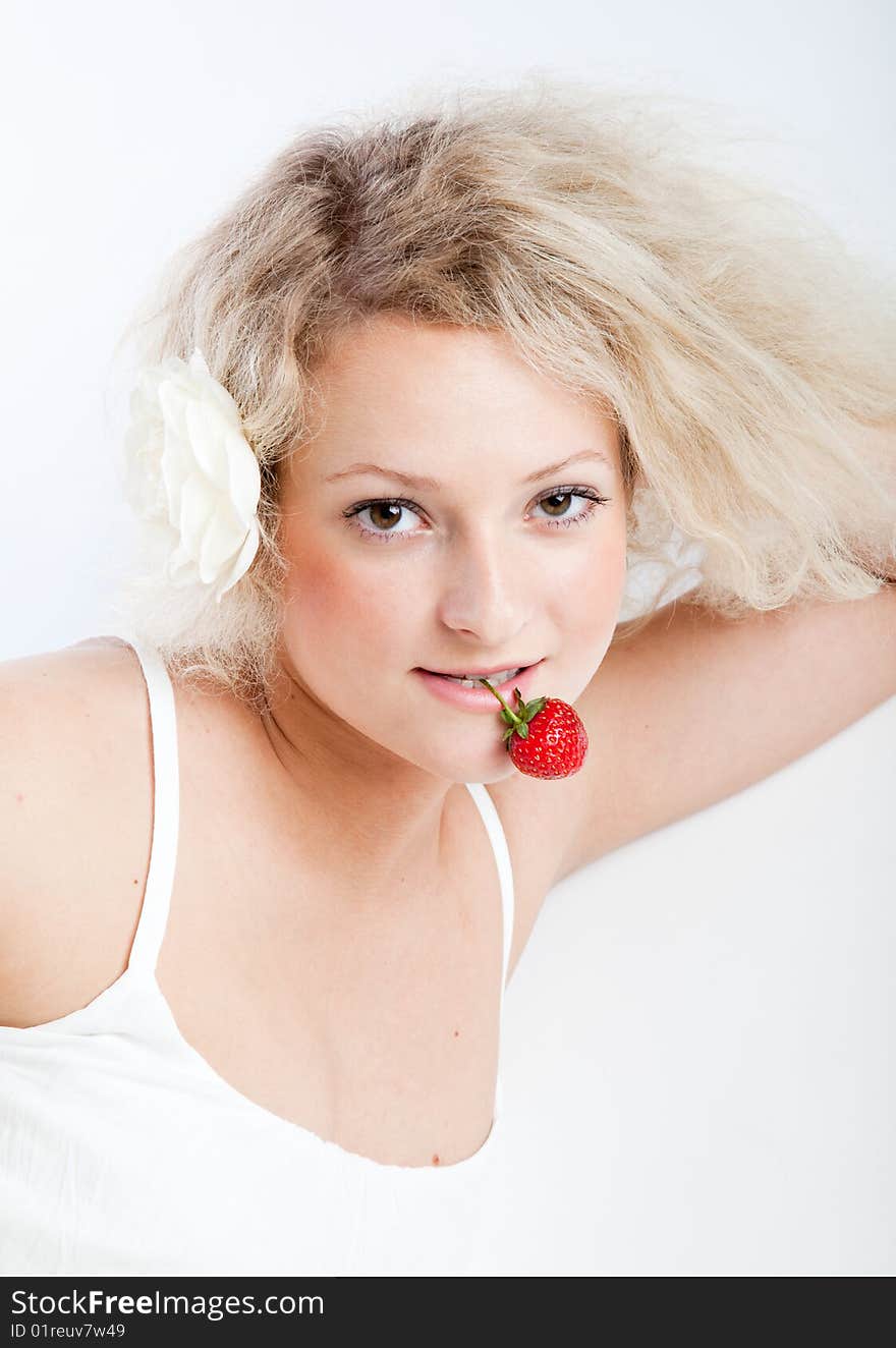 Young woman in white dress eating strawberries. Isolated on white background