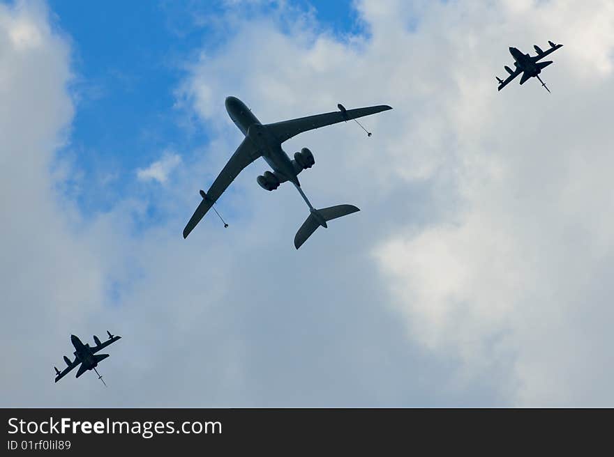 One big and two small planes against the blue sky and white clouds. One big and two small planes against the blue sky and white clouds