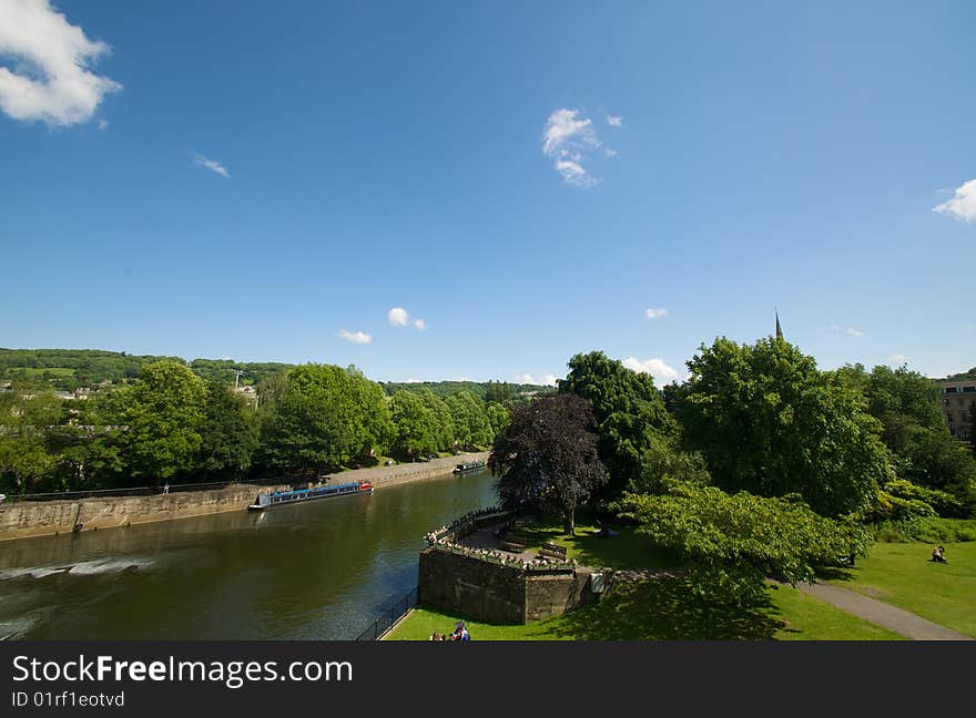 Fine park with the big green trees on river bank