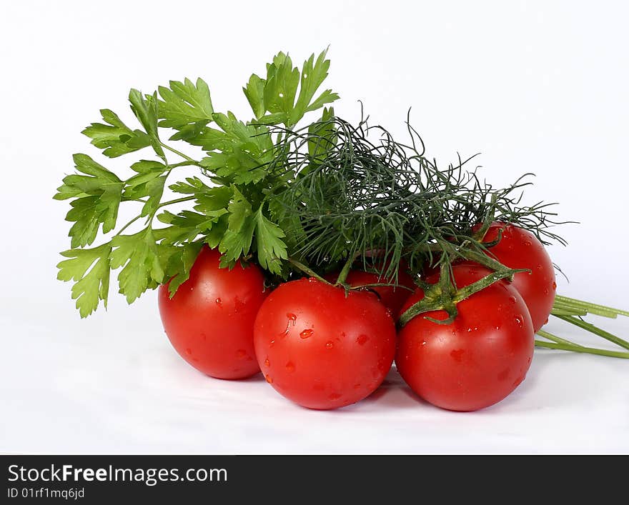 Some juicy tomatoes and greens bunches on a white background. Some juicy tomatoes and greens bunches on a white background