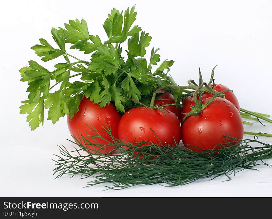 Some juicy tomatoes and parsley leaves on a white background. Some juicy tomatoes and parsley leaves on a white background