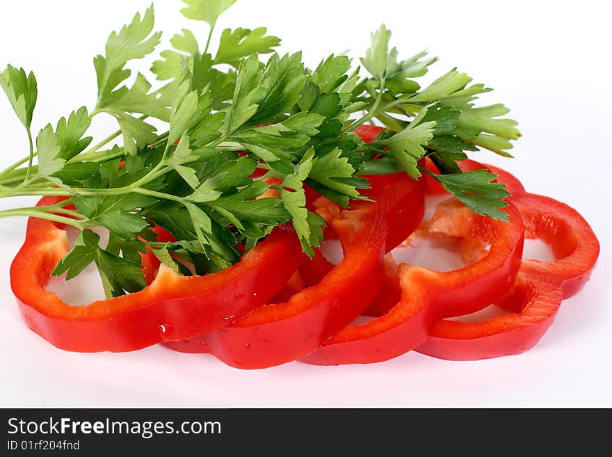 The cut sweet pepper and parsley leaves on a white background. The cut sweet pepper and parsley leaves on a white background