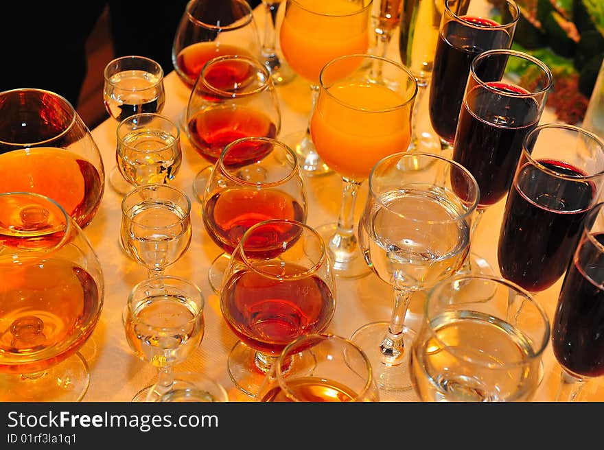 On a table stand with wine glasses, vodka, champagne and cognac. On a table stand with wine glasses, vodka, champagne and cognac