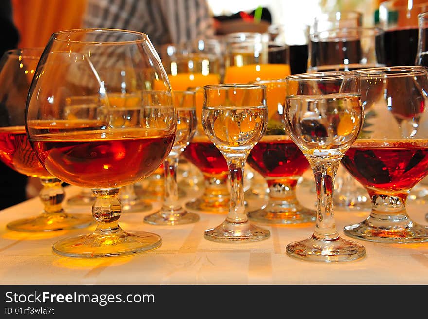 On a table stand with wine glasses, vodka, champagne and cognac. On a table stand with wine glasses, vodka, champagne and cognac