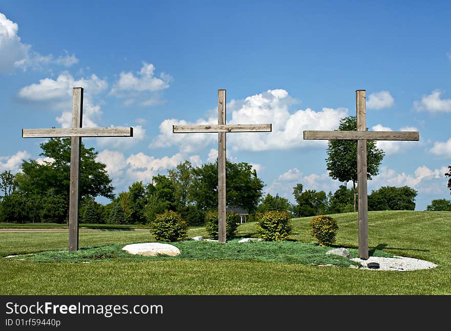 Three wooden crosses stand as Christian symbols of Jesus Christ's crucifixion at Calvary. Three wooden crosses stand as Christian symbols of Jesus Christ's crucifixion at Calvary.