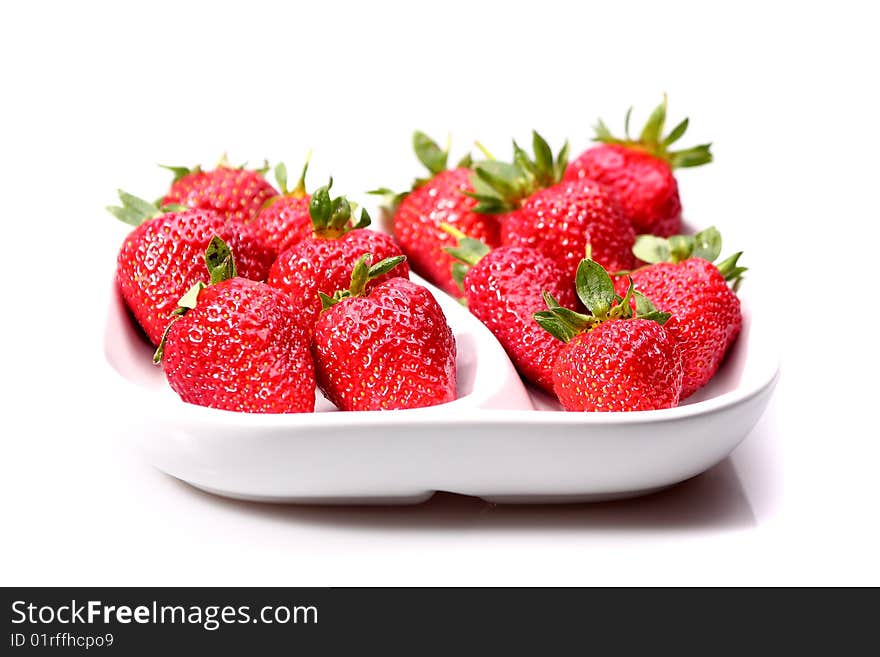 Strawberries in a white dish on a white background