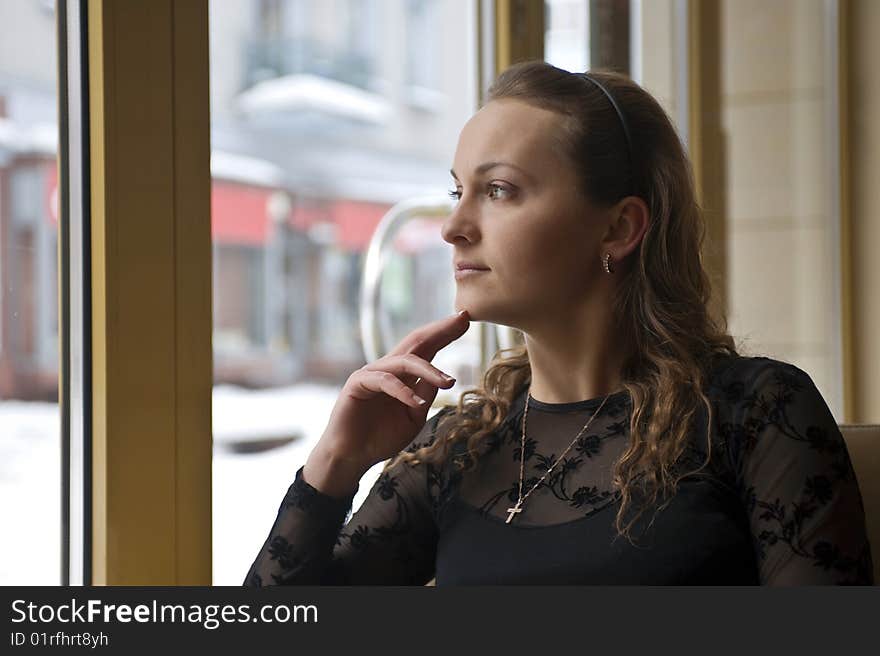 Girl sitting near the window in the restaurant. Girl sitting near the window in the restaurant