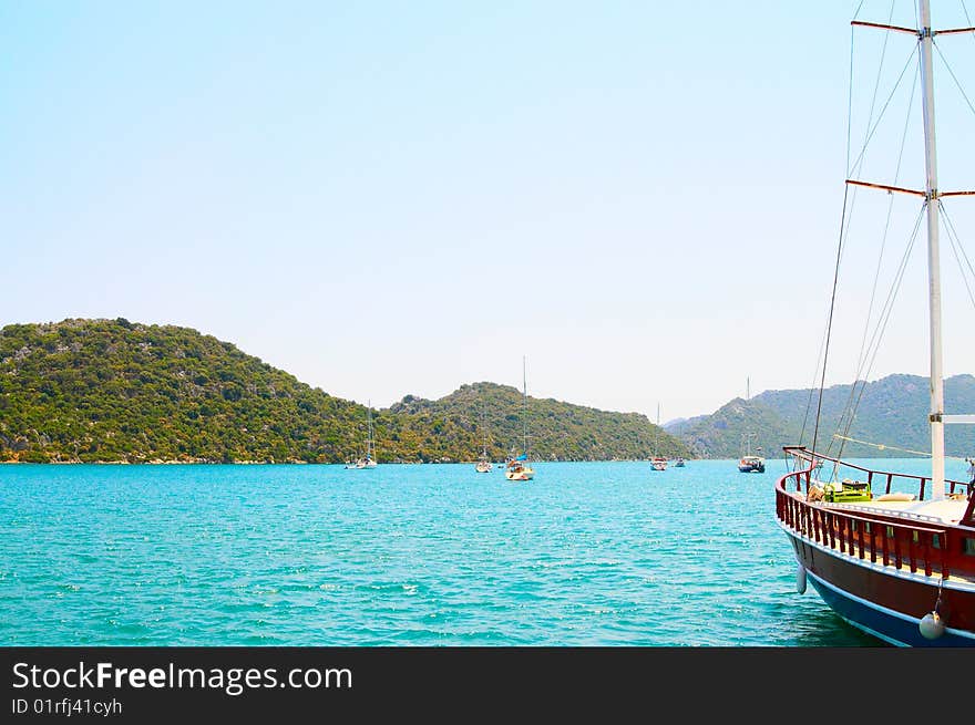 The yachts in bay next to splendid mountains. The yachts in bay next to splendid mountains.