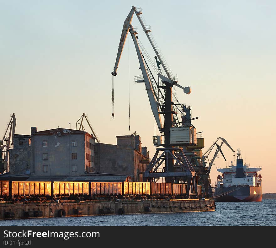 The cargo ship is loaded by coal in Riga port.