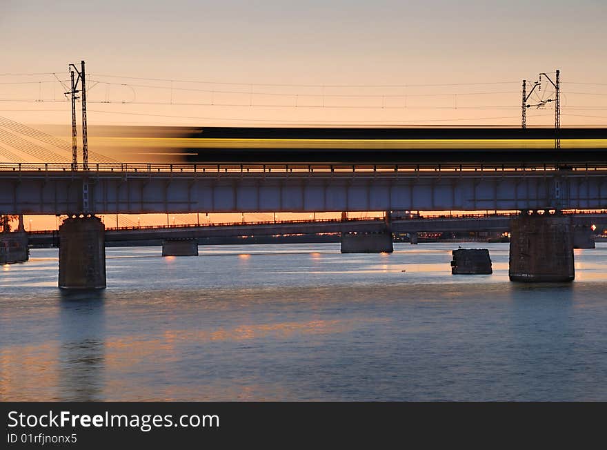 The morning express train on the bridge across Daugava river.