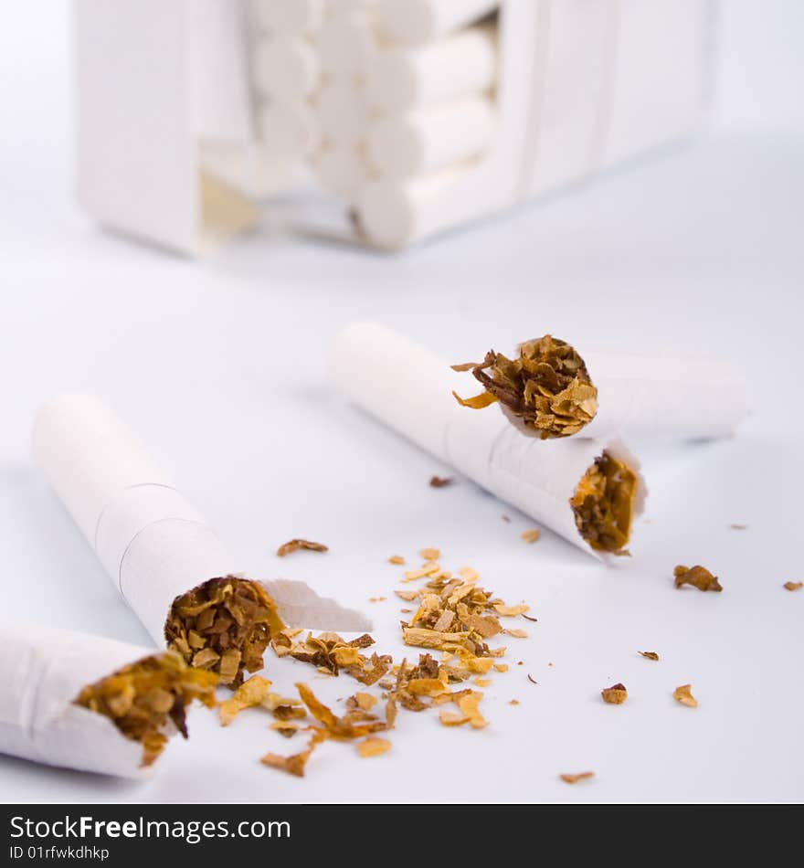 Broken cigarettes on white background