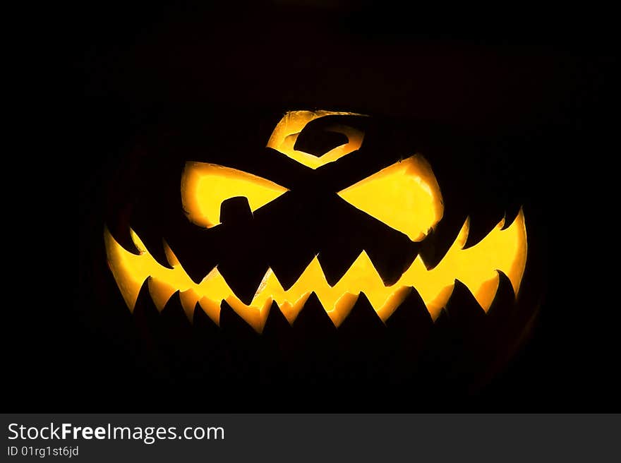 Jack-o'-lantern, spooky Halloween pumpkin face glowing in the night