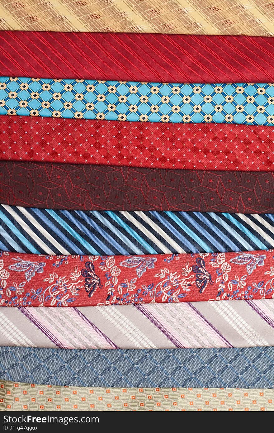 Varicoloured silk ties are put in row, macro. Varicoloured silk ties are put in row, macro