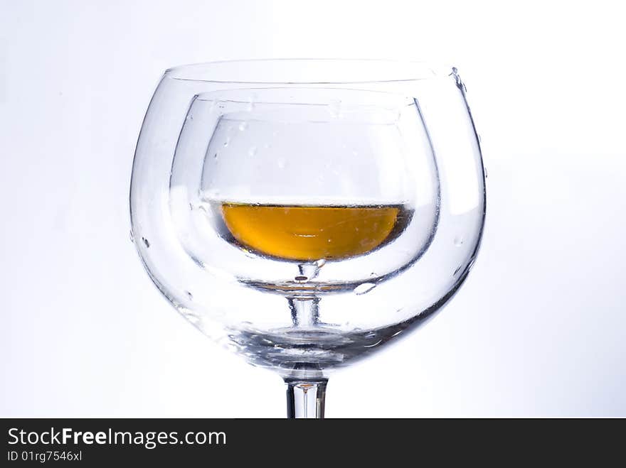 Shot of two empty glasses and one glass with wine. Shot of two empty glasses and one glass with wine.