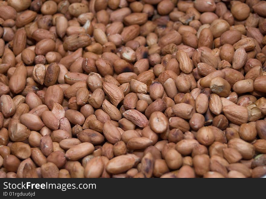 Many peanuts close up, brown background. Many peanuts close up, brown background