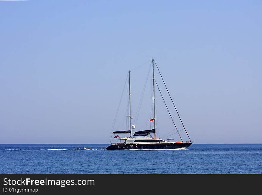 White sailboat floating on the blue sea