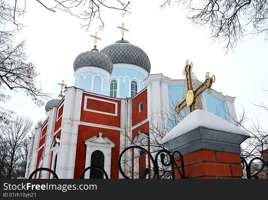 Orthodox church in a frame of trees against the sky.