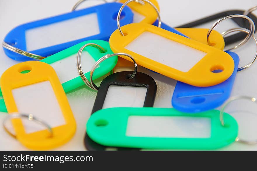 Plastic keyrings with labels in different colors on a white background. Plastic keyrings with labels in different colors on a white background