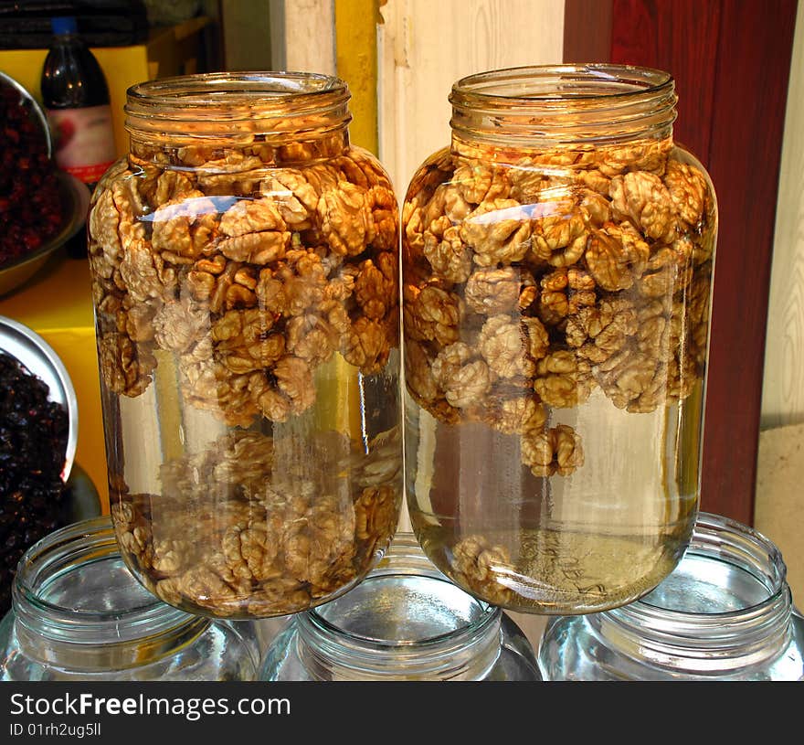 Peeled walnuts in water in glass jars in a street