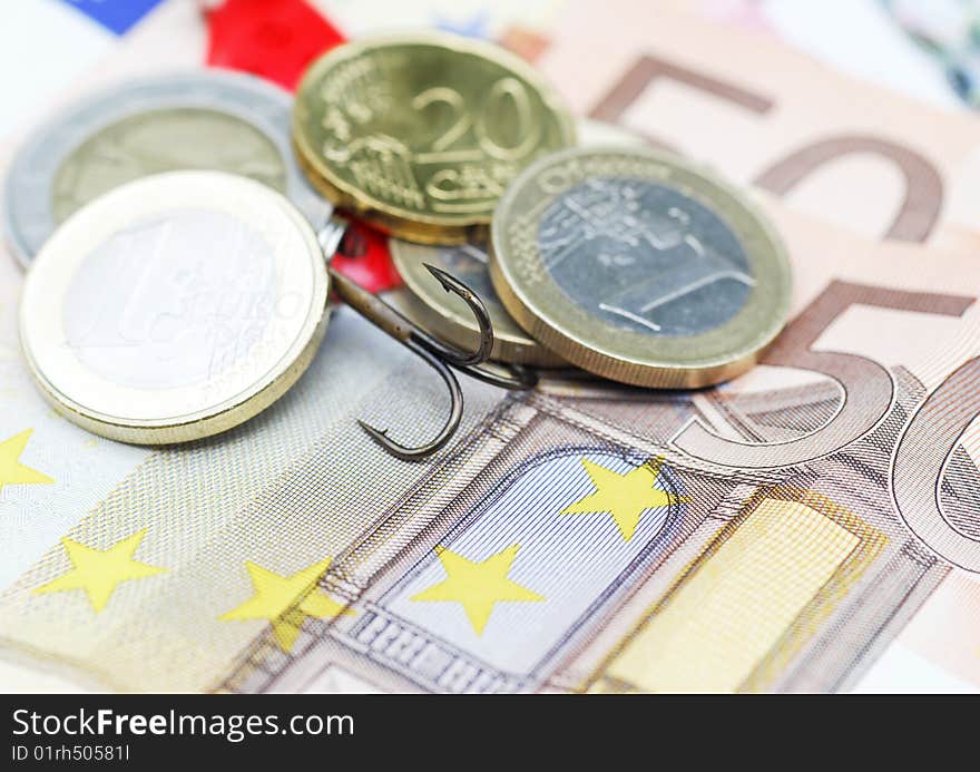 Close-up of fishing hook hidden in Euro currency. Close-up of fishing hook hidden in Euro currency