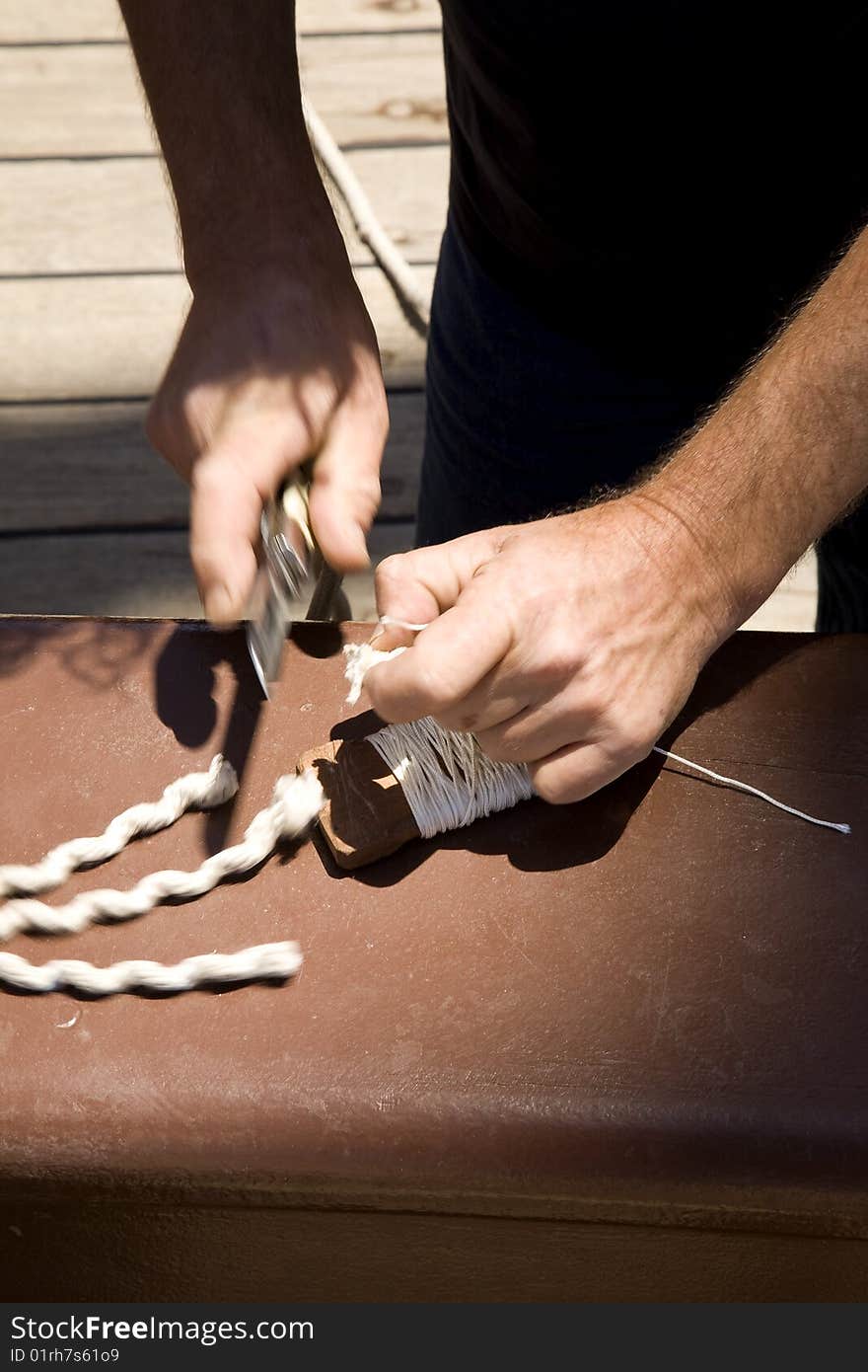 Sailor cutting cables in a ship s deck