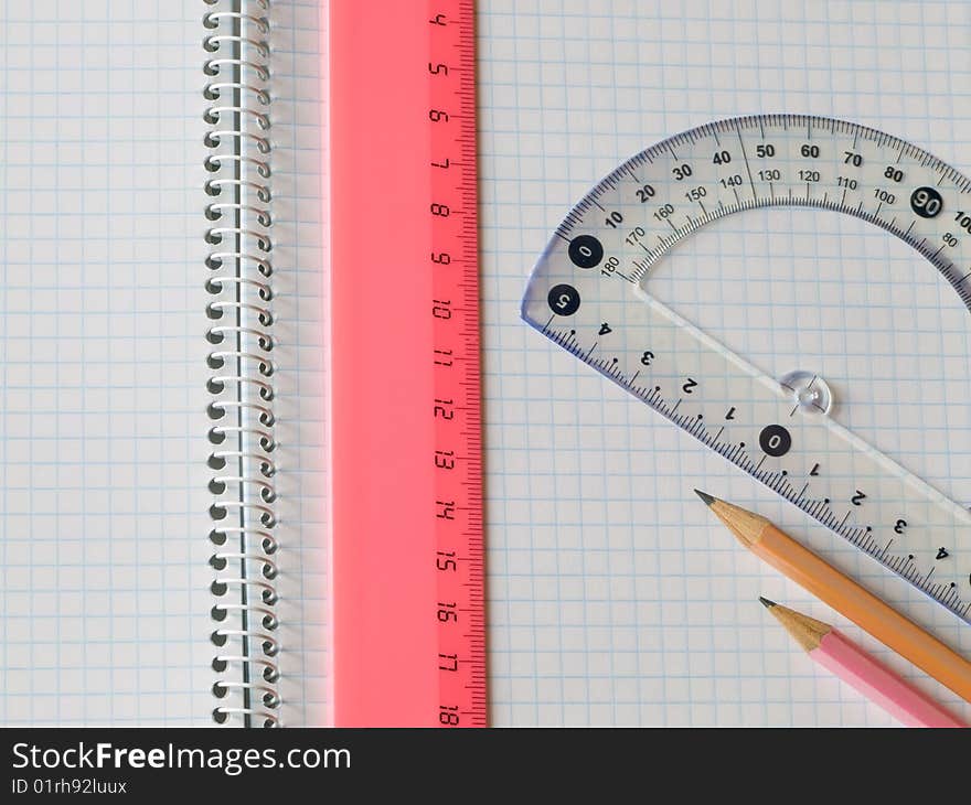 Ruler and pencils on squared sheet of a copybook. Ruler and pencils on squared sheet of a copybook