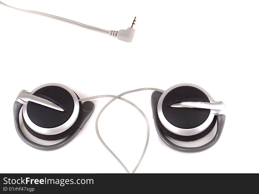 Small easy ear-phones of silvery colour with a cable and the plug.