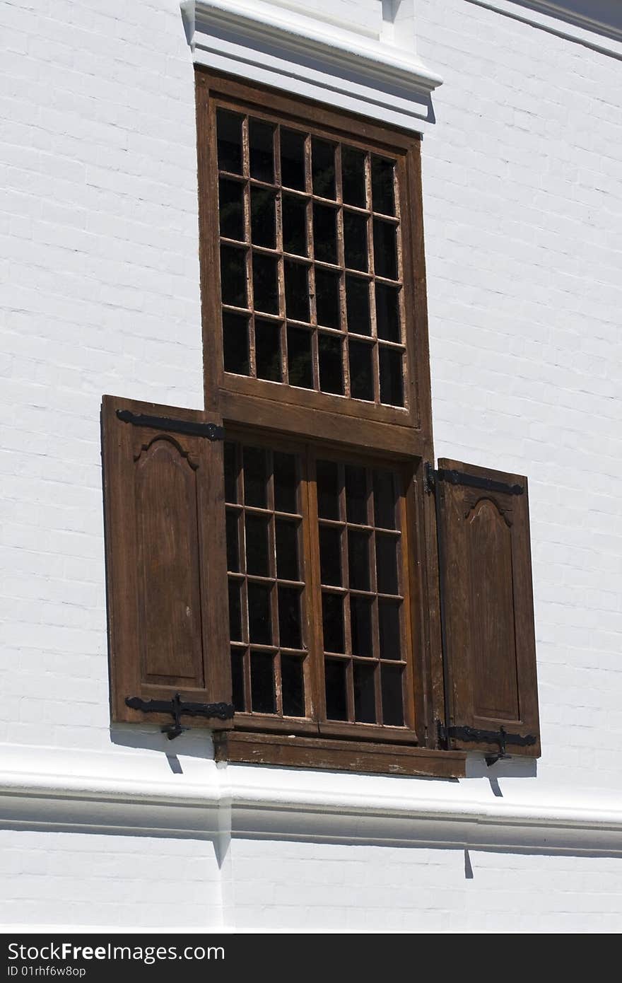 Wooden shutters and wooden window panes on a white wall. Wooden shutters and wooden window panes on a white wall