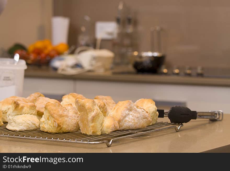 Scones that have just cam out of the oven, ready after being baked, with the cooking utensils in the background. Scones that have just cam out of the oven, ready after being baked, with the cooking utensils in the background.