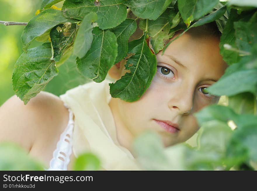 The girl looks out because of summer foliage. The girl looks out because of summer foliage