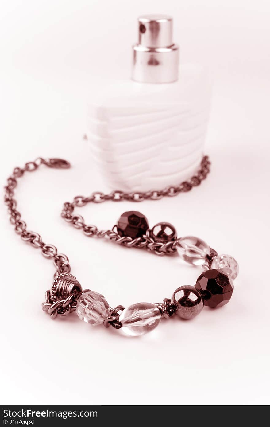 Black necklace and parfume bottle on a white background