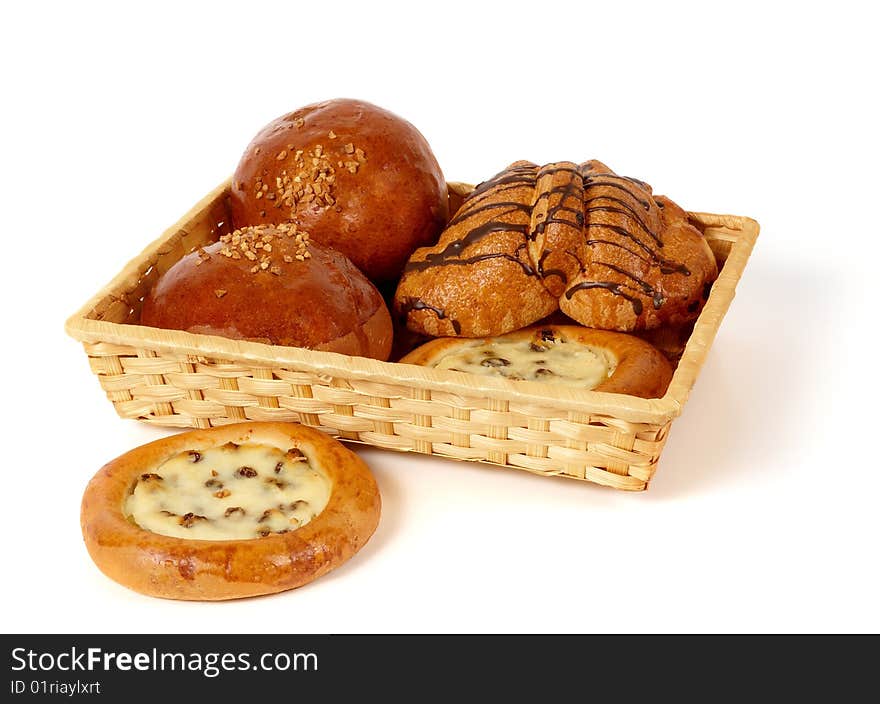 There are different types of pastry in the basket. With roasted peanuts, raisins, cottage cheese ad chocolate glaze. Isolated on white background. There are different types of pastry in the basket. With roasted peanuts, raisins, cottage cheese ad chocolate glaze. Isolated on white background.