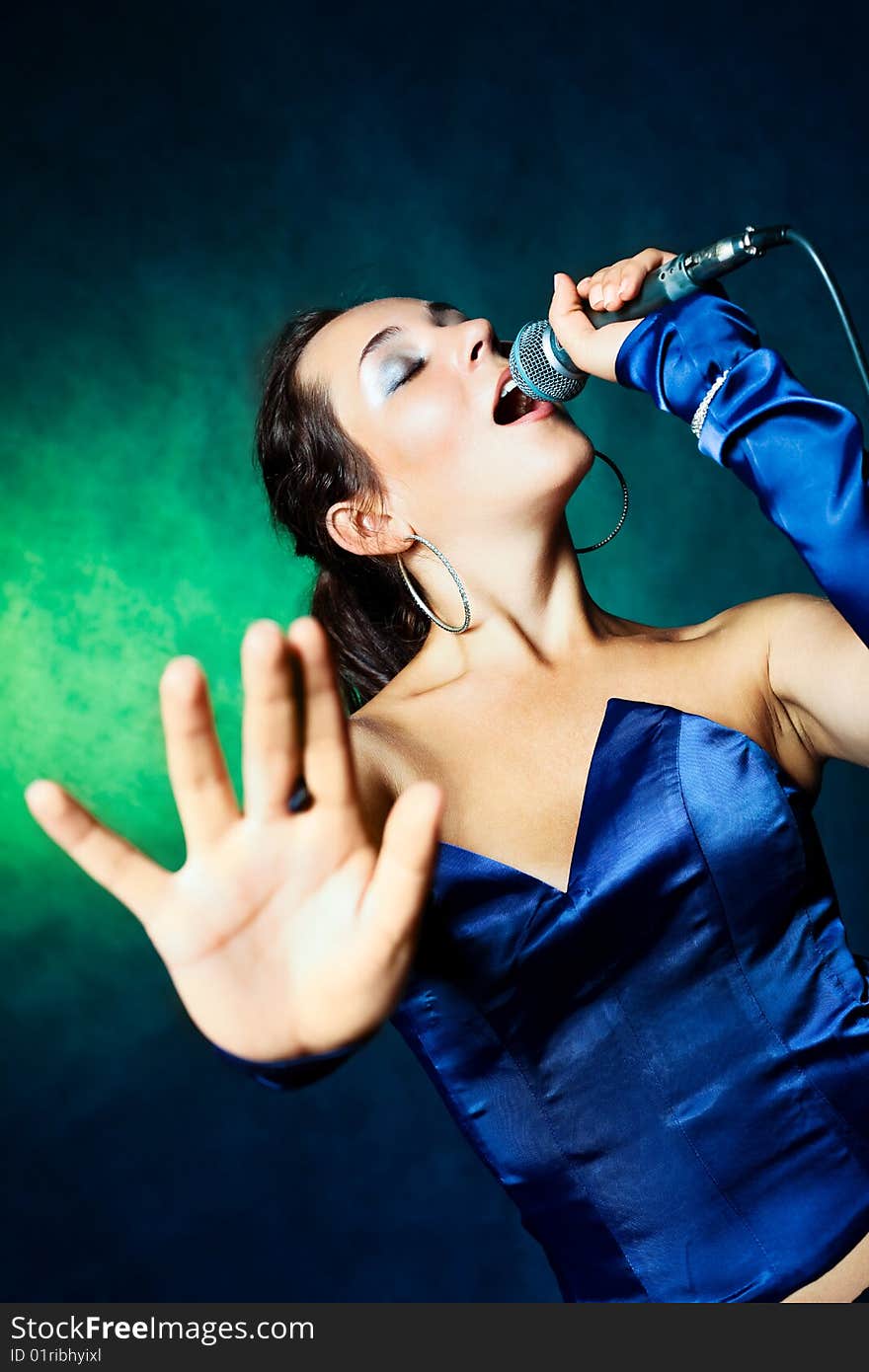 Sexy young woman singing with a microphone. Sexy young woman singing with a microphone