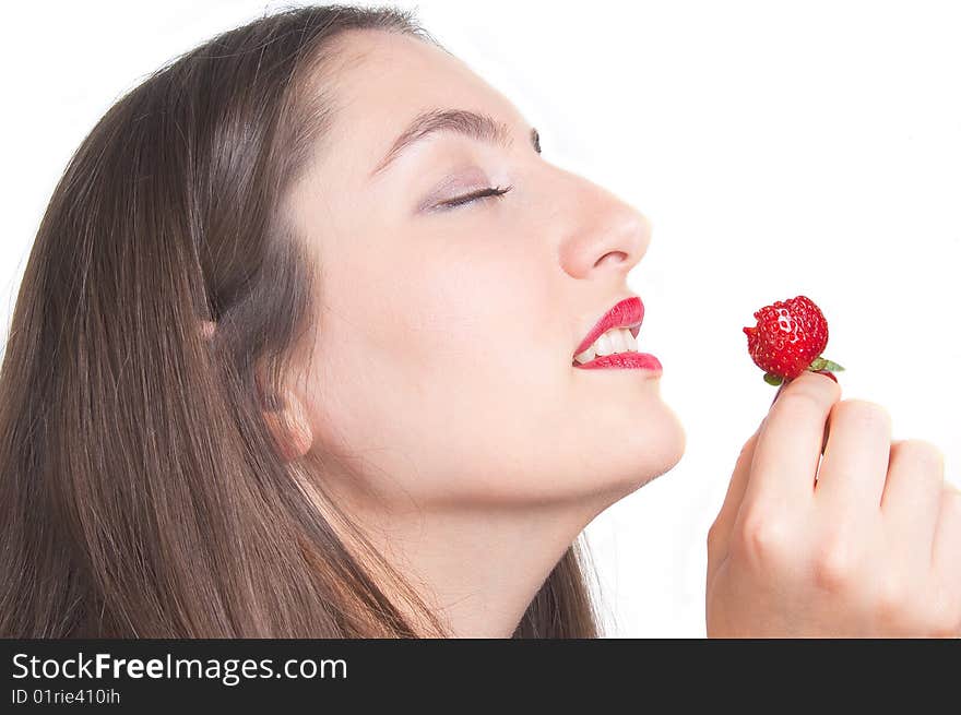 A young lady is tasteing a strawberry. A young lady is tasteing a strawberry