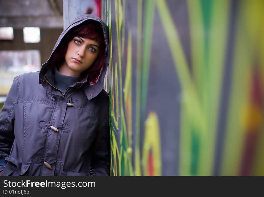 Girl posing by the graffiti wall in a jacket. Girl posing by the graffiti wall in a jacket