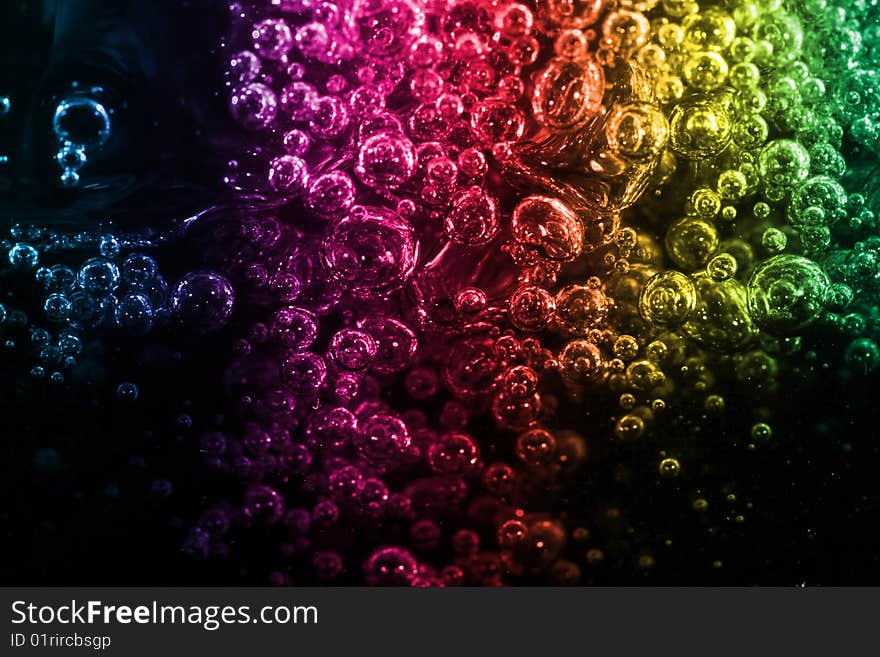 Macro of colorful air bubbles underwater against black background