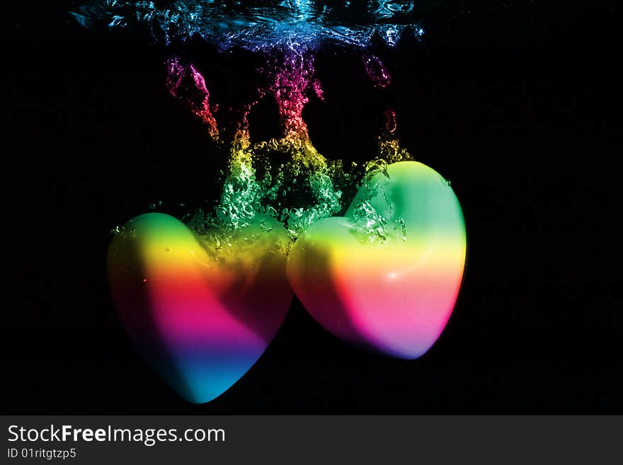 Colorful Hearts splashing underwater against black background. Colorful Hearts splashing underwater against black background