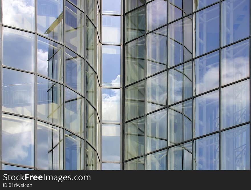 The sky is reflected in the windows of the office workplace.