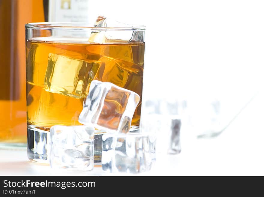 Alcoholic beverage whith ice cubes isolated over white