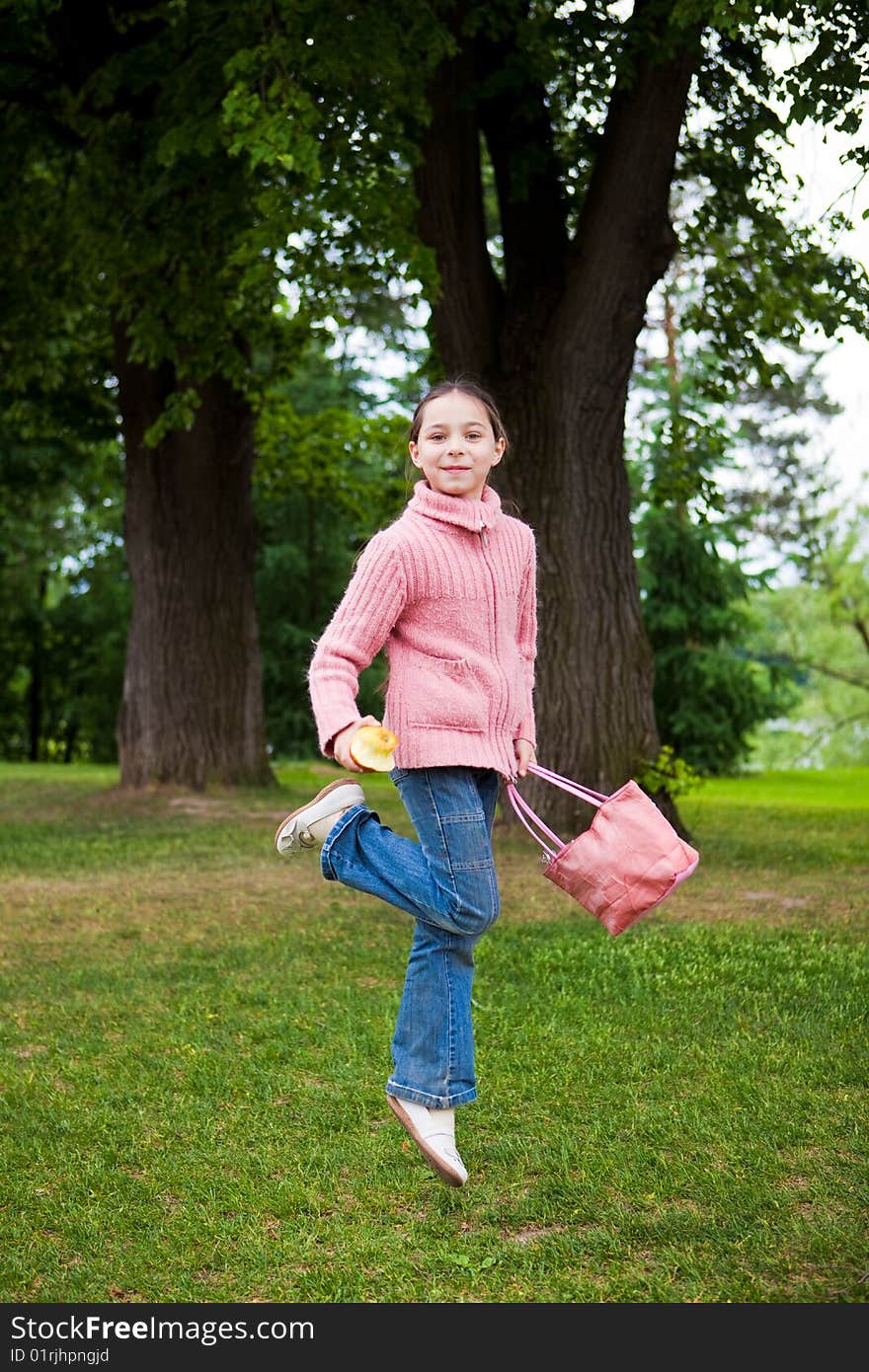 Girl jumps on a green grass against trees. Girl jumps on a green grass against trees