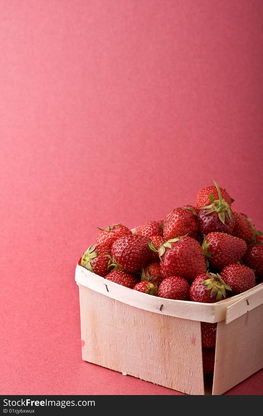 Wooden quart of ripe strawberries on a solid background. Wooden quart of ripe strawberries on a solid background