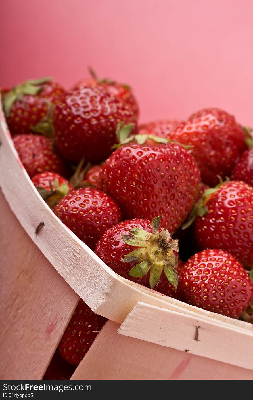 Wooden quart of ripe strawberries on a solid background. Wooden quart of ripe strawberries on a solid background