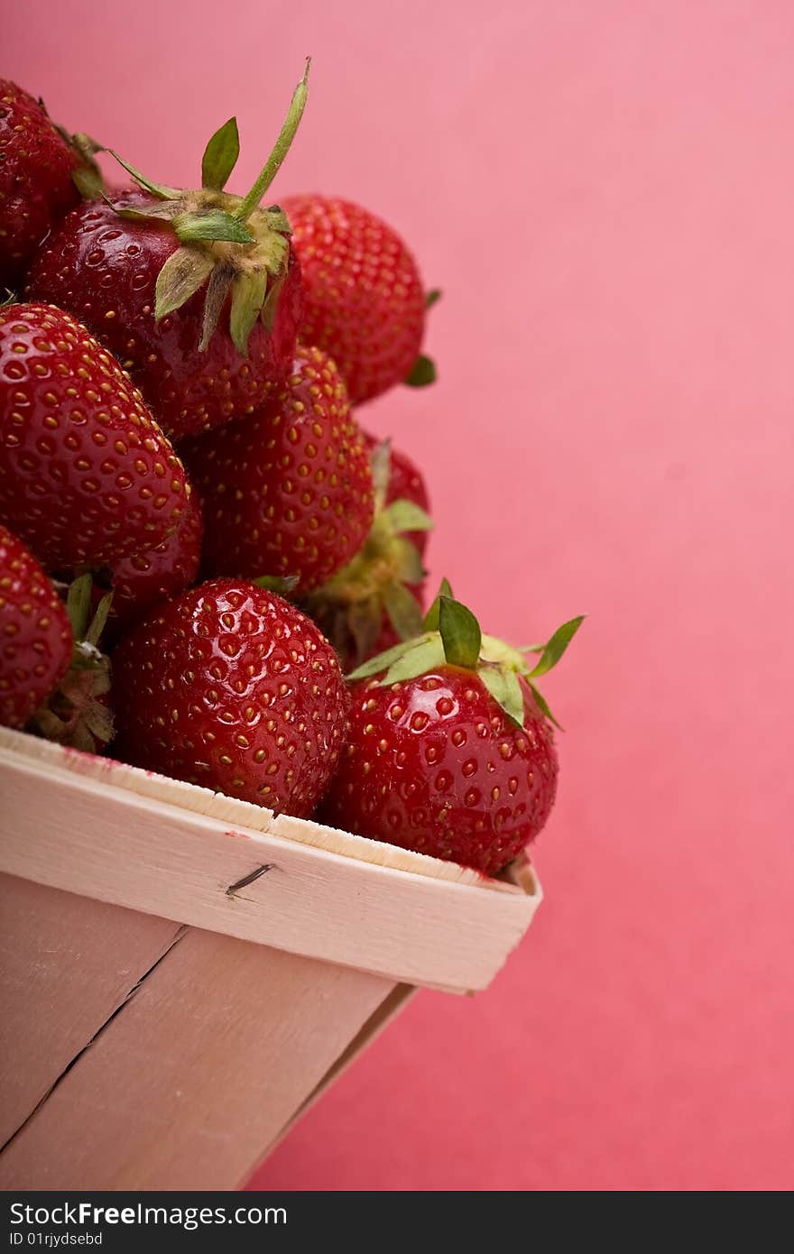 Wooden quart of ripe strawberries on a solid background. Wooden quart of ripe strawberries on a solid background