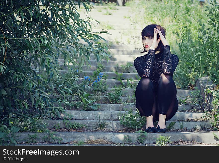 Stylish girl sits on the stair in the park. Stylish girl sits on the stair in the park.