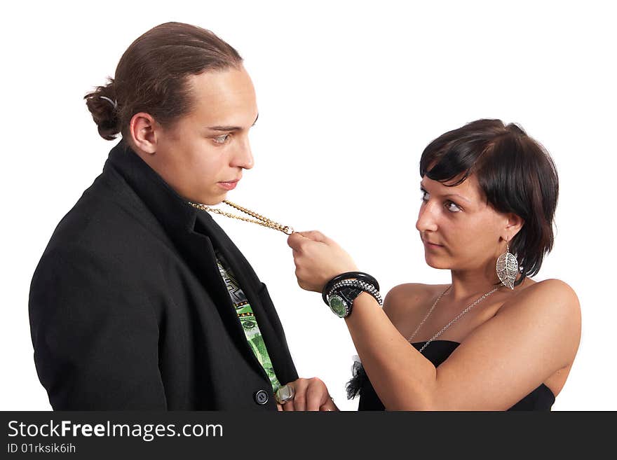 Young couple in love is about to kiss. The woman is pulling the man closer with his necklace. Isolated over white. Young couple in love is about to kiss. The woman is pulling the man closer with his necklace. Isolated over white.